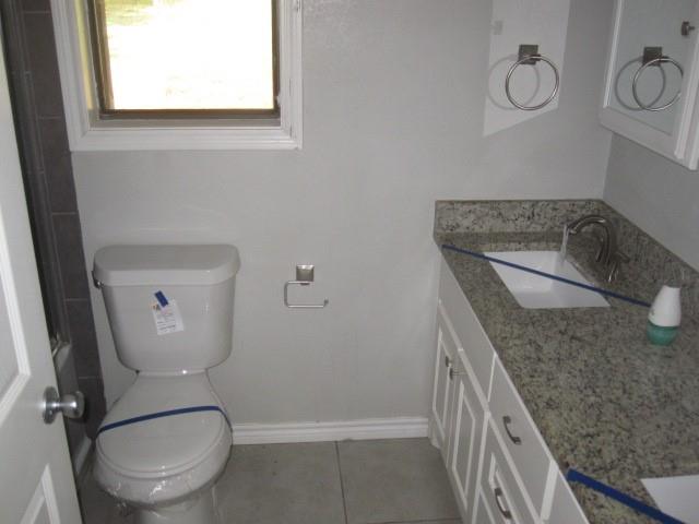2801 Pyramid Circle Denison, TX 75020 - Photo 8 of 18 a bathroom with a granite countertop toilet a sink and mirror