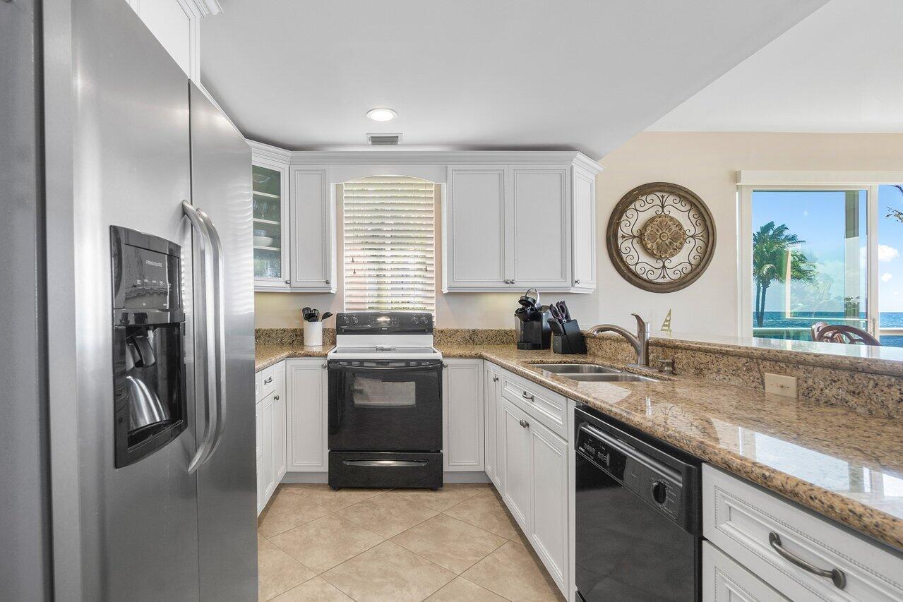 120 Inlet Way, Unit 204 Palm Beach Shores, FL 33404 - Photo 13 of 27 a kitchen with stainless steel appliances granite countertop a sink a stove a refrigerator and island