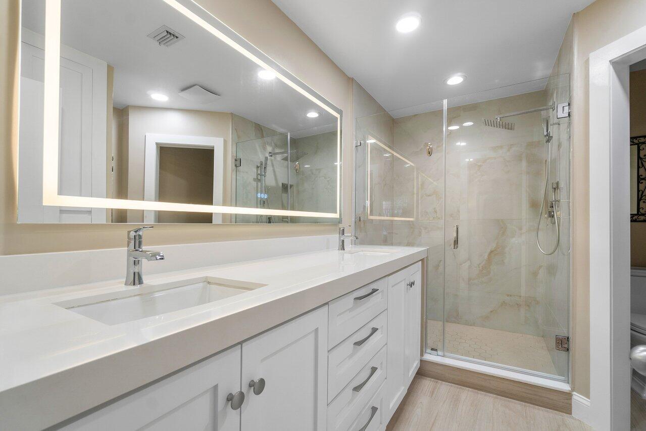 120 Inlet Way, Unit 204 Palm Beach Shores, FL 33404 - Photo 20 of 27 a bathroom with double sink and a mirror