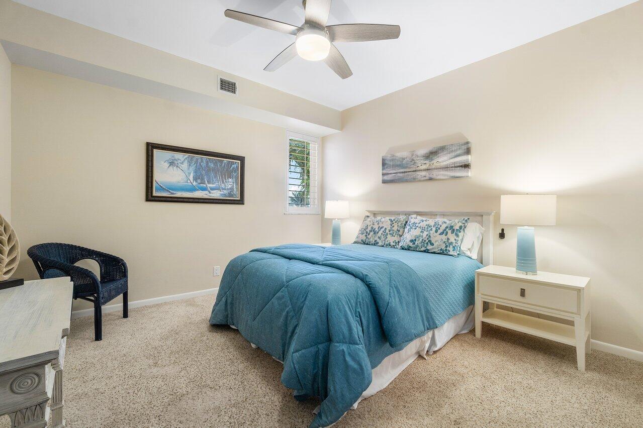120 Inlet Way, Unit 204 Palm Beach Shores, FL 33404 - Photo 22 of 27 a bedroom with a bed and a chandelier