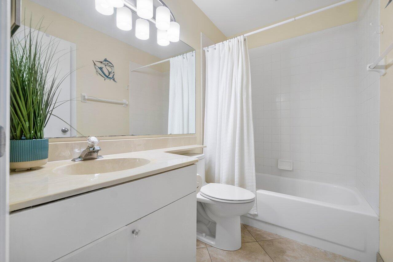 120 Inlet Way, Unit 204 Palm Beach Shores, FL 33404 - Photo 23 of 27 a bathroom with a granite countertop sink a toilet and bathtub
