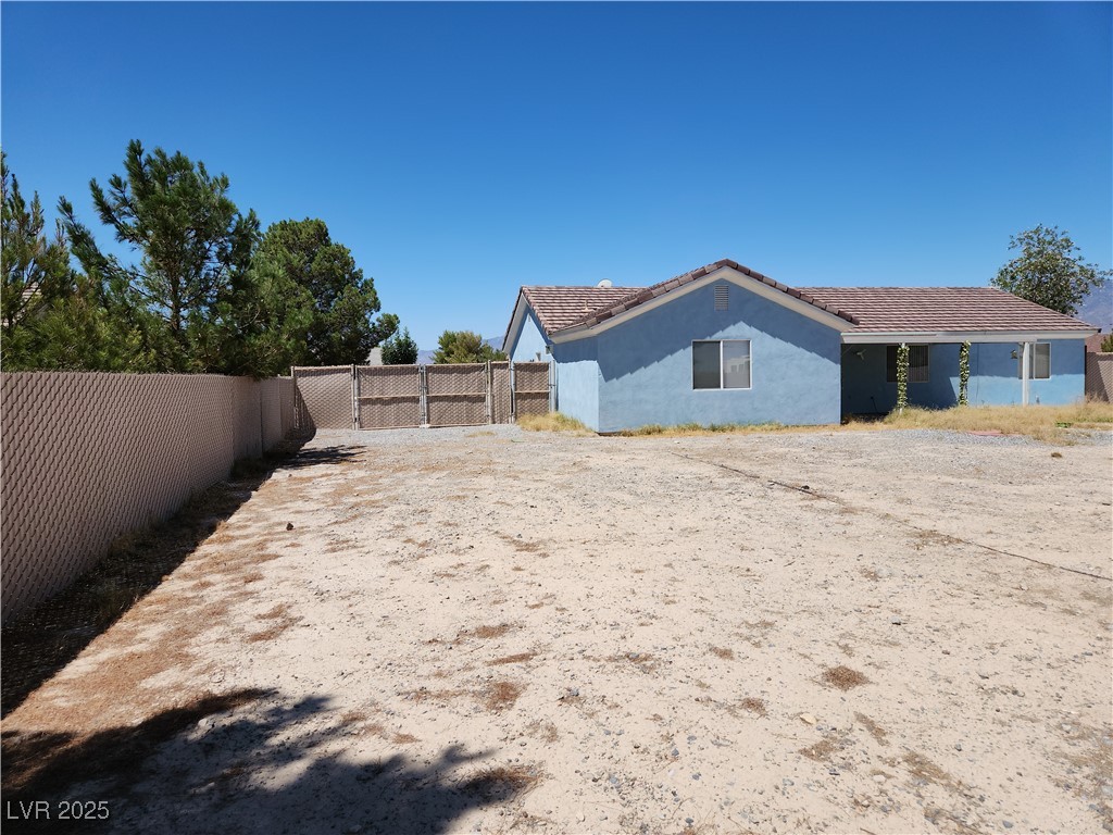 161 Diamond Bar Road Pahrump, NV 89048 - Photo 21 of 29 Rear view of property with a fenced backyard, stucco siding, and a tile roof