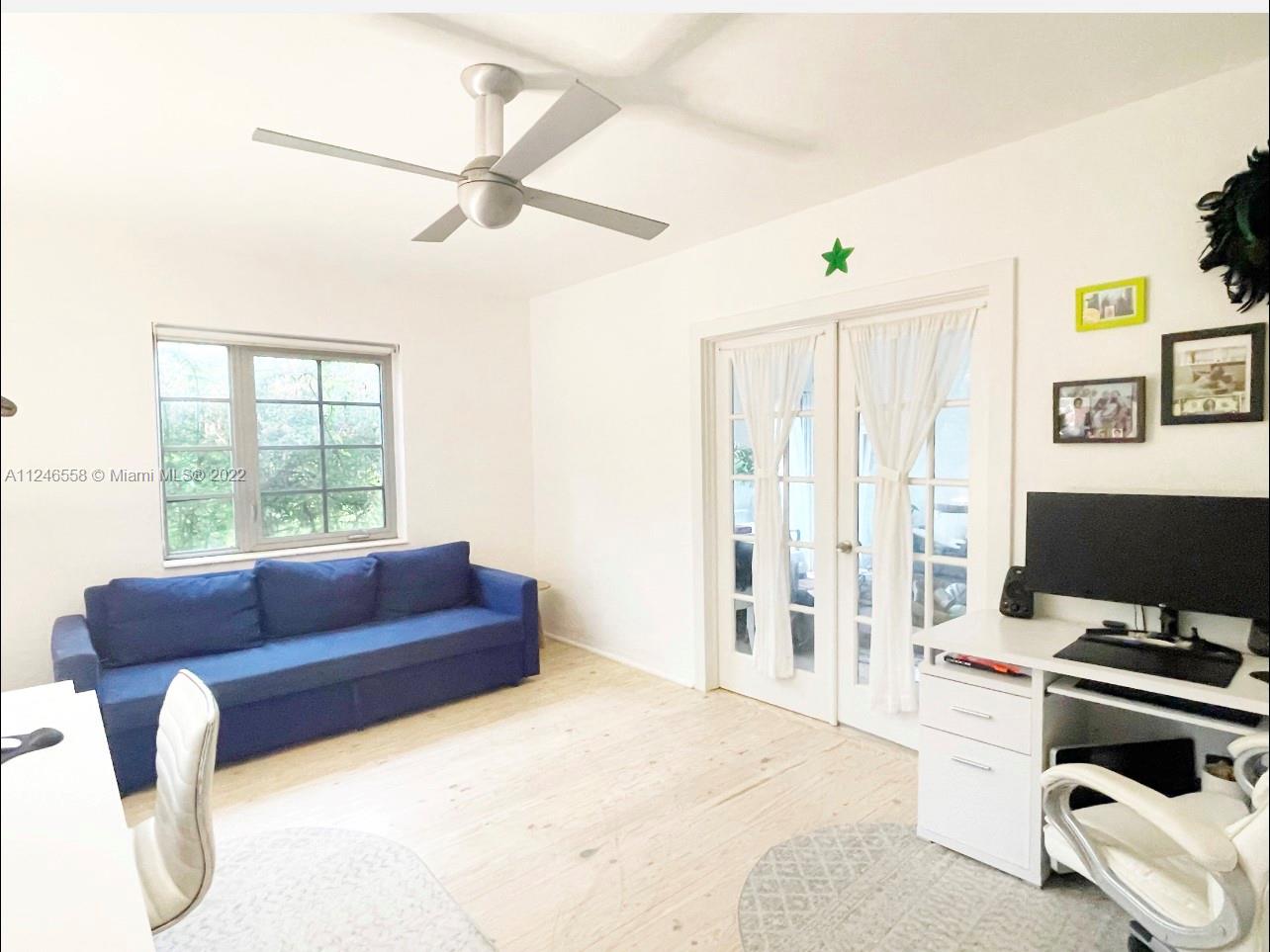 840 Michigan Avenue, Unit 1 Miami Beach, FL 33139 - Photo 1 of 7 a living room with furniture and a flat screen tv