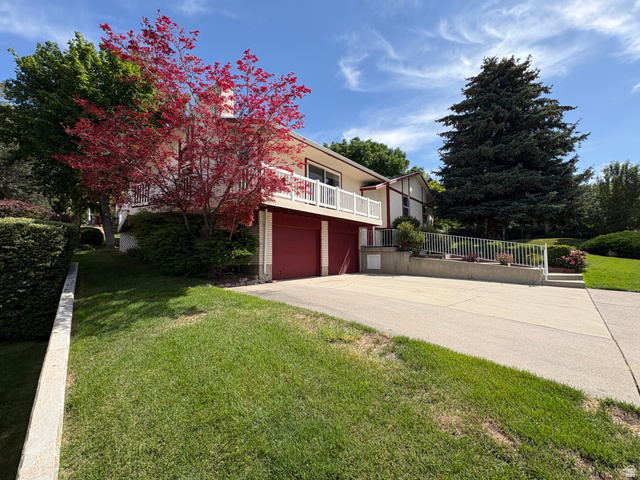 595 Meadowlark Road Orem, UT 84097 - Photo 82 of 87 Multi-level residence featuring a two-car garage with red doors and a white exterior facade
