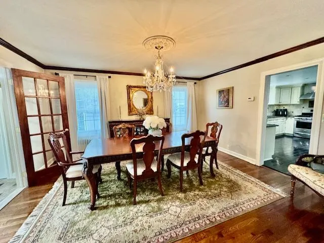 a view of a dining room with furniture a chandelier and wooden floor