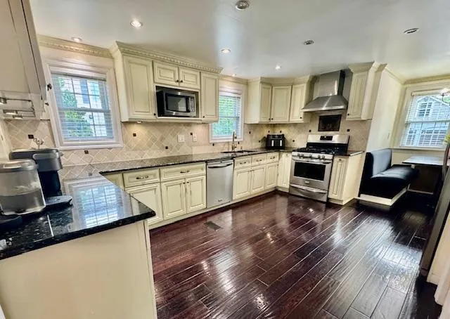 a kitchen with stainless steel appliances granite countertop a sink wooden cabinets and a refrigerator