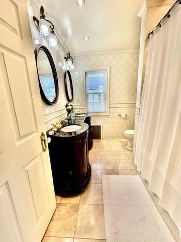 a bathroom with a sink and mirror with bathtub