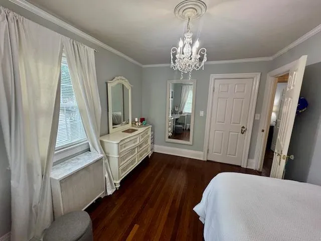 a view of a bedroom with wooden floor and stairs