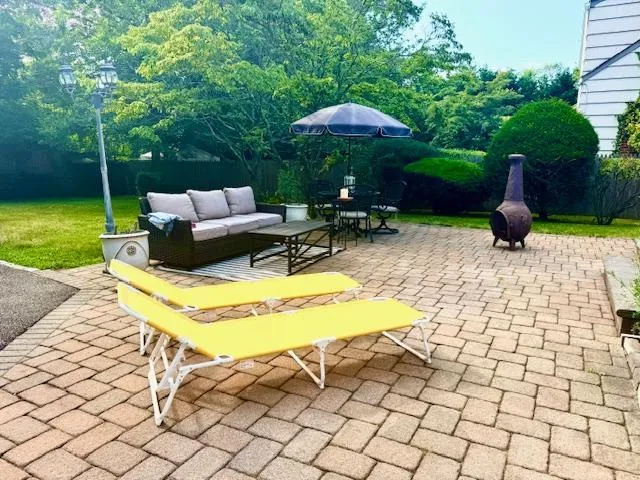 a view of a patio with a table and chairs under an umbrella