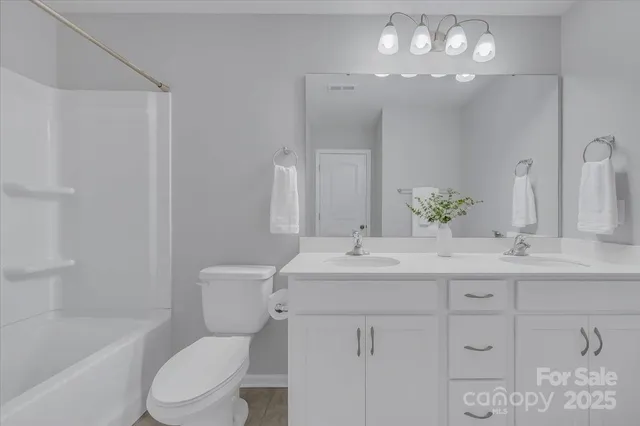 a bathroom with a toilet a sink a tub and a mirror