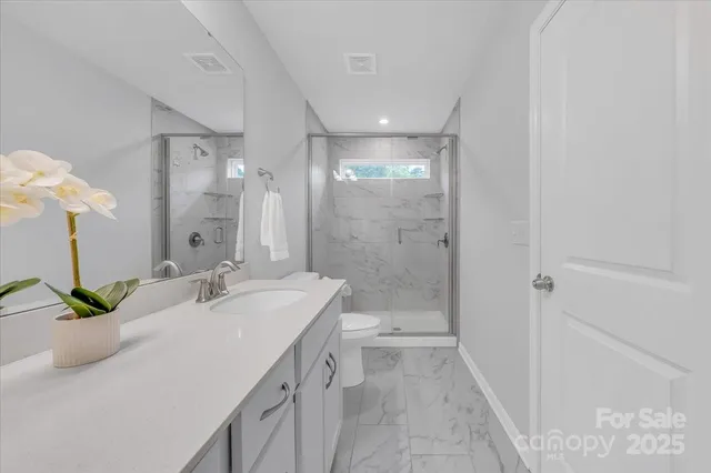 a bathroom with a double vanity sink toilet and shower
