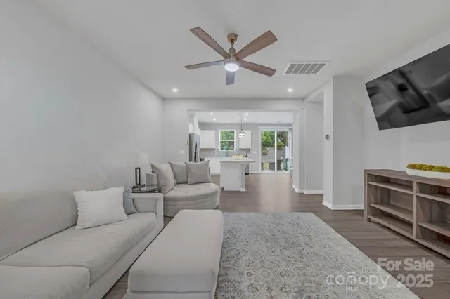 a living room with furniture a ceiling fan and a rug