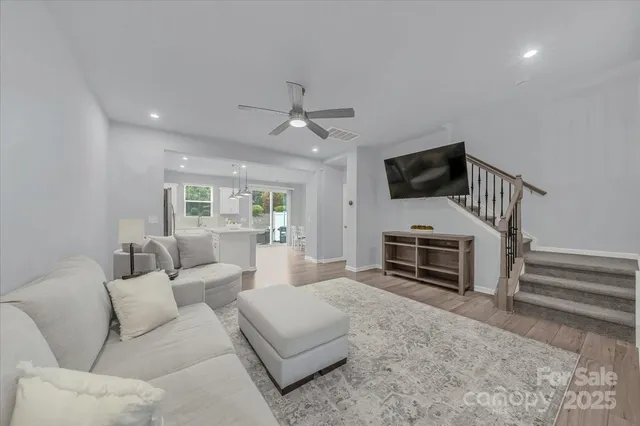 a living room with furniture a flat screen tv and kitchen view