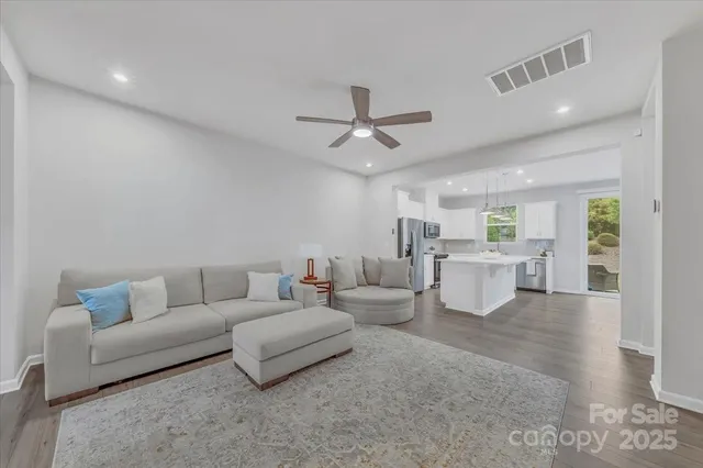a living room with furniture and view of kitchen