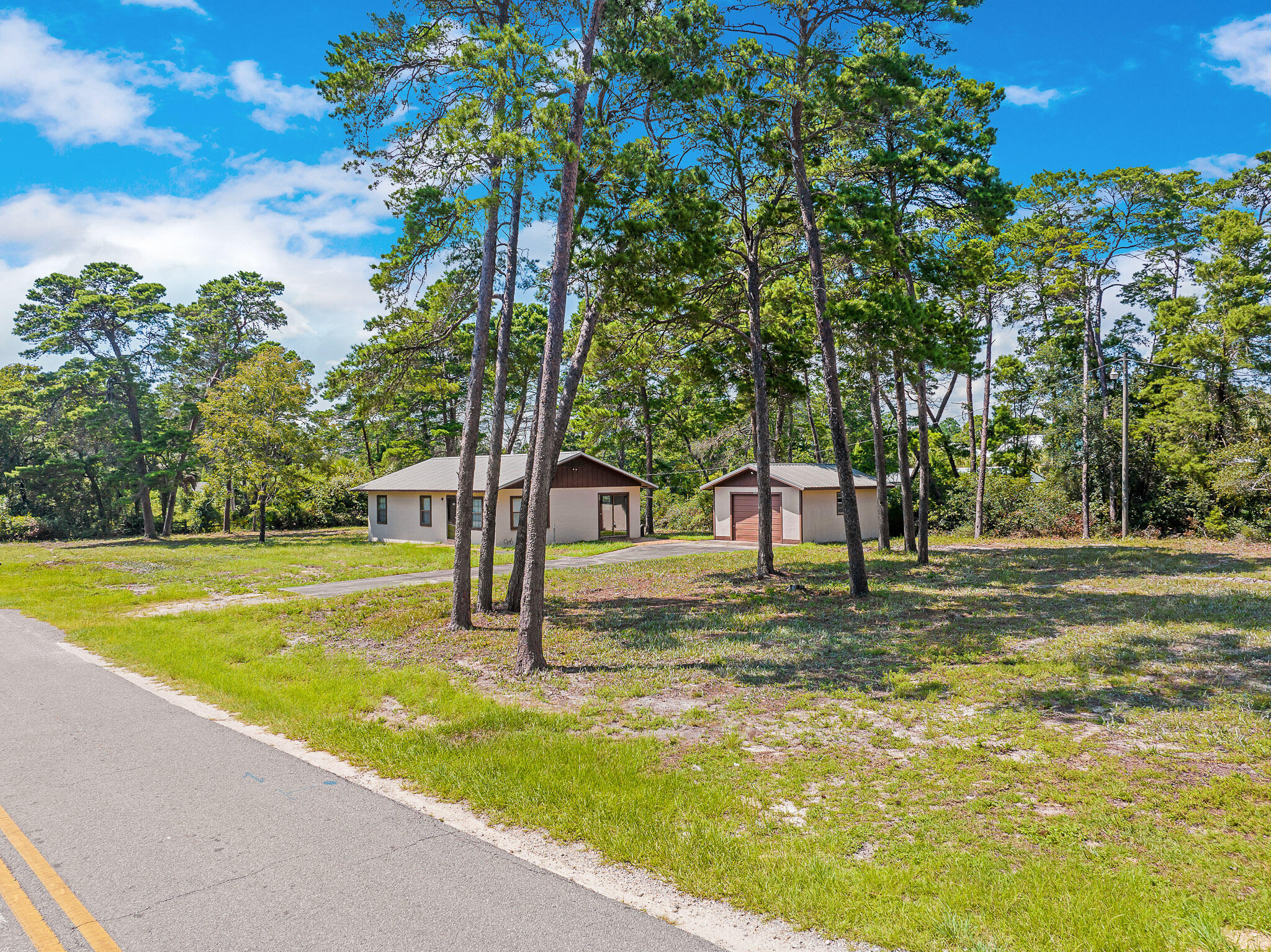323 Pinewood Lane Inlet Beach, FL 32461 - Photo 19 of 50 a view of a fountain in front of a house with large trees