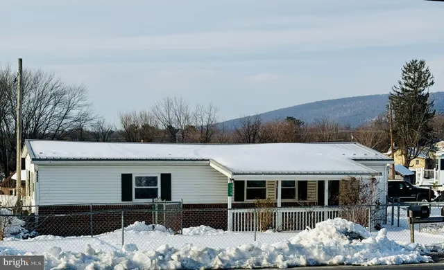 a view of house with yard and covered with snow