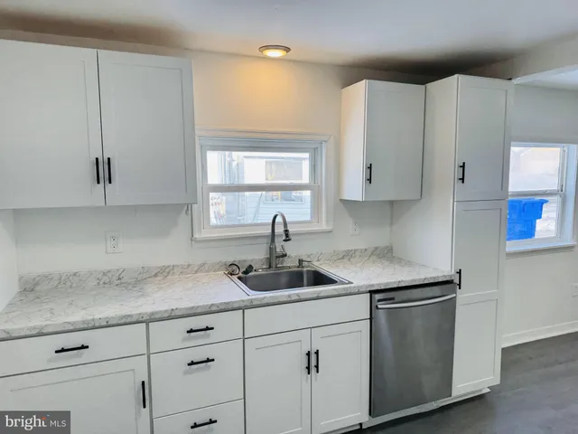 a kitchen with white cabinets and a sink