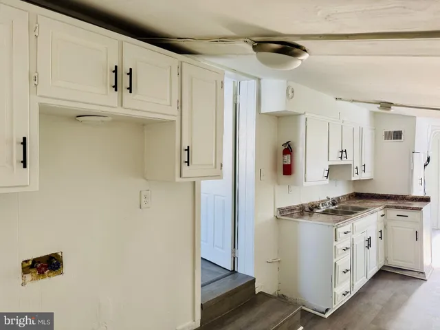 a kitchen with stainless steel appliances a refrigerator a stove and white cabinets