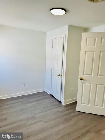 an empty room with wooden floor and closet