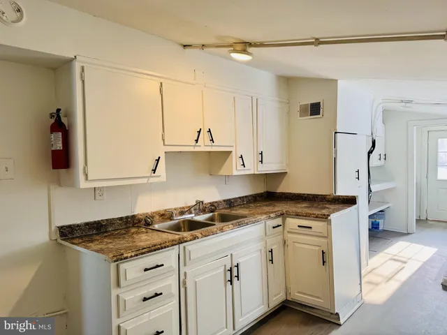 a kitchen with granite countertop a sink stove and cabinets