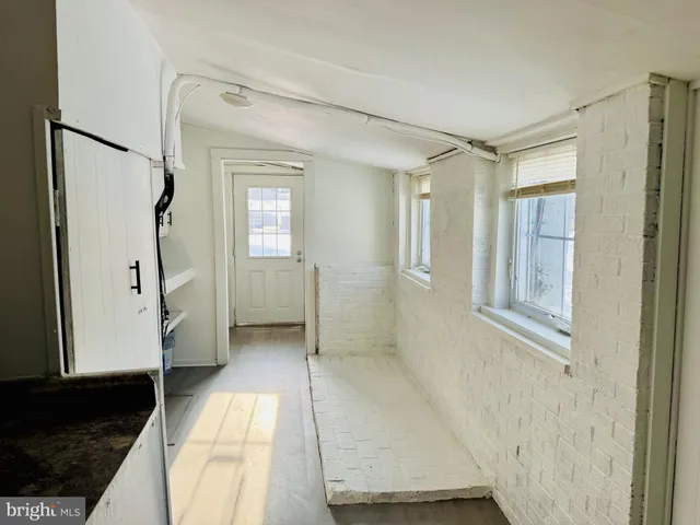 a view of an empty room with a fireplace and a window
