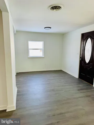 a view of a room with wooden floor and window
