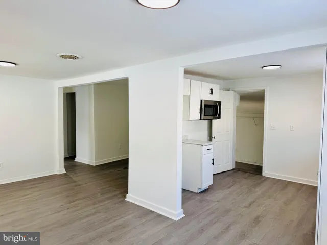 an empty room with wooden floor and mirror