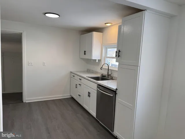 a kitchen with sink cabinets and stove top oven