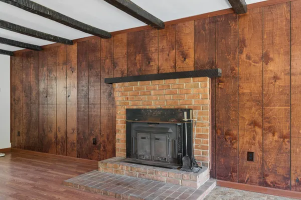 a view of a livingroom with wooden floor and a fireplace