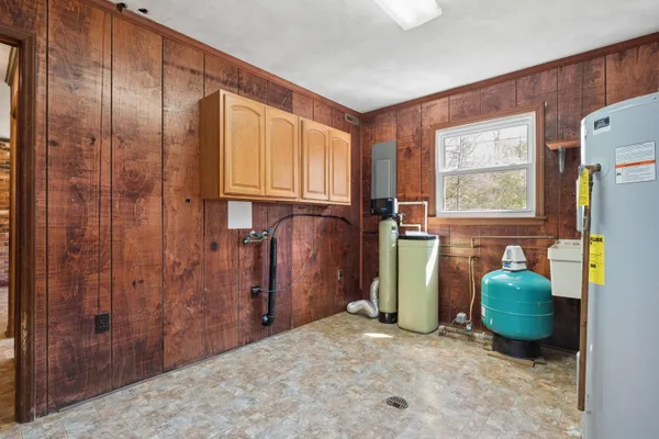 a view of an empty room with wooden floor and window