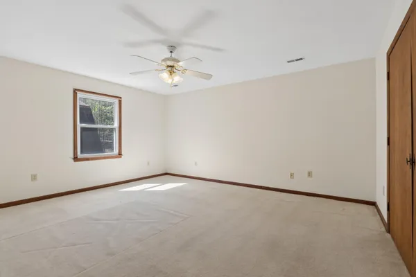 an empty room with chandelier fan