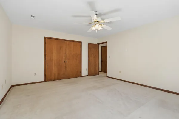 an empty room with a window and a fan