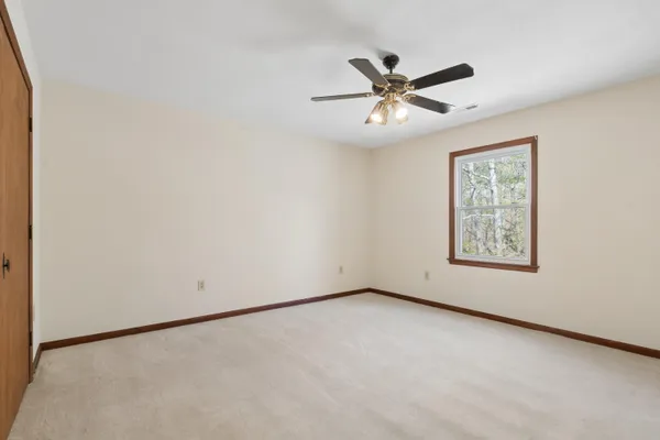 an empty room with chandelier fan