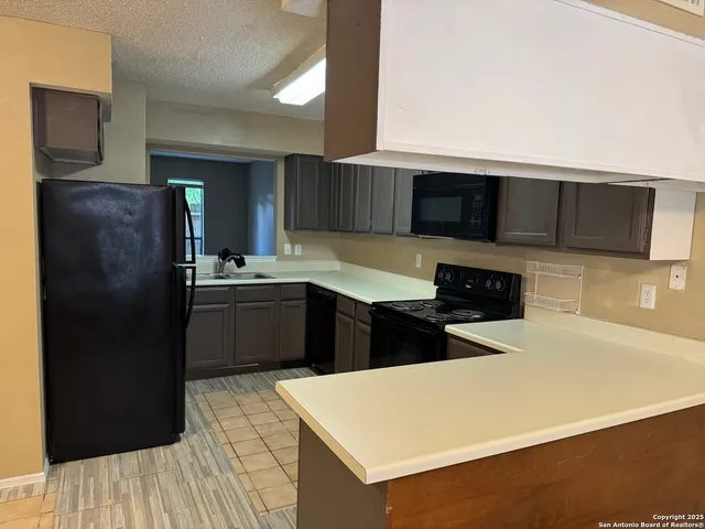 a kitchen with stainless steel appliances a refrigerator and a stove top oven