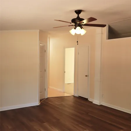 a view of a room with wooden floor and fan