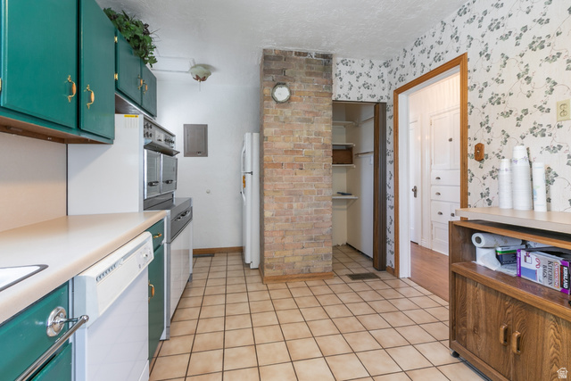 59 East Pinehurst Street Tooele, UT 84074 - Photo 9 of 22 Kitchen featuring tile flooring, green cabinetry, a built-in oven, and a brick accent wall