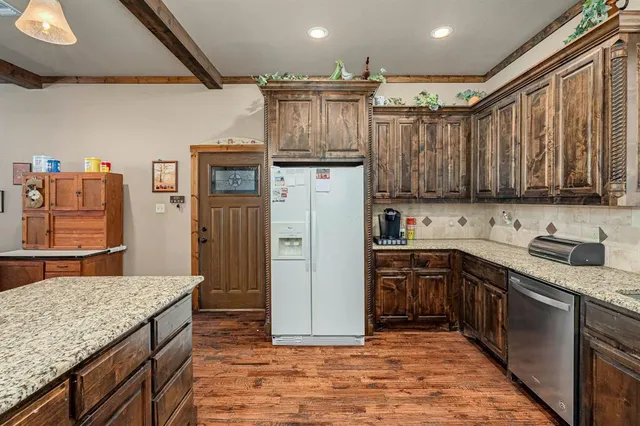 a kitchen with stainless steel appliances granite countertop a refrigerator stove and sink
