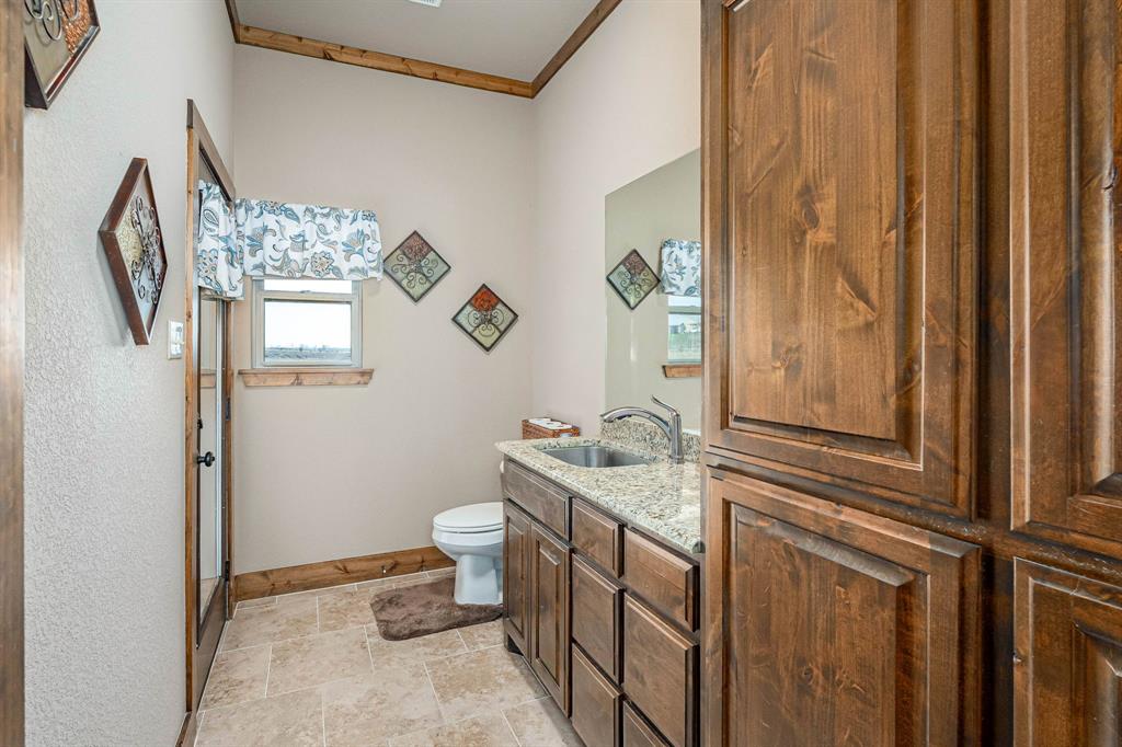 3028 Harrell Road Howe, TX 75459 - Photo 15 of 39 This half-bath is located near the laundry room and service as a convenient bathroom for guests. It also serves as a mud room as it has a large sink and door access fto the outside rear of the home. Great additional cabinet storage area.