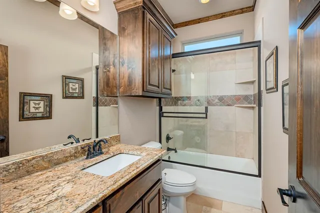 a bathroom with a granite countertop sink toilet and shower