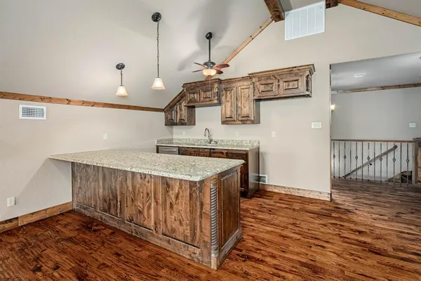a kitchen with a sink and wooden floor