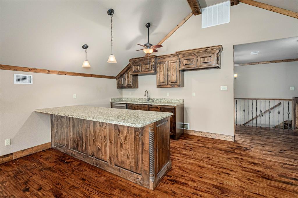 3028 Harrell Road Howe, TX 75459 - Photo 21 of 39 Present in the game room is a large granite top counter seating island, sink, dishwasher & cabinet storage. Room for a refrigerator.