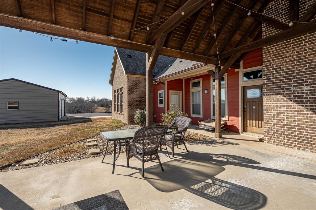 3028 Harrell Road Howe, TX 75459 - Photo 26 of 39 View showing the covered area by the back door and a glimpse of the outbuliding.