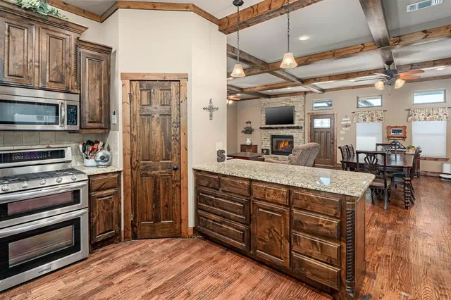a kitchen with stainless steel appliances granite countertop a refrigerator and a stove top oven