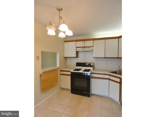 a kitchen with a stove cabinets and a window
