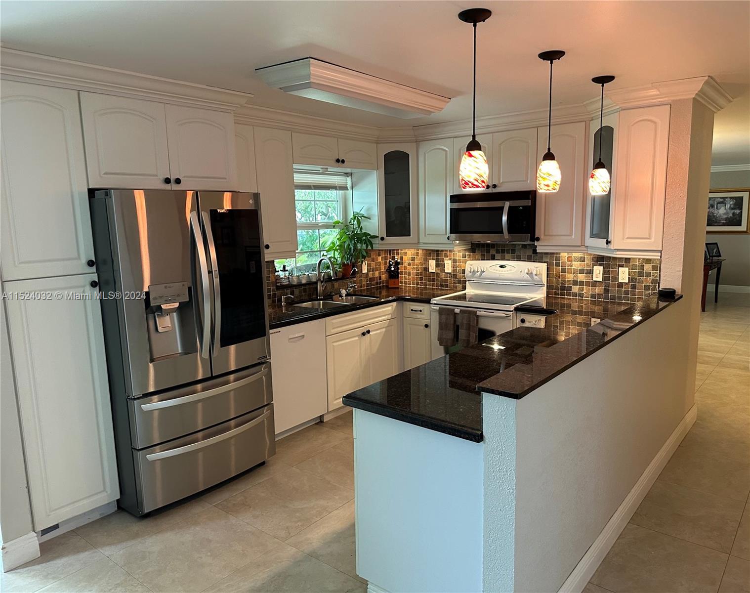 14944 Southwest 144th Court Miami, FL 33186 - Photo 11 of 34 a kitchen with stainless steel appliances granite countertop a refrigerator a sink a stove and a refrigerator