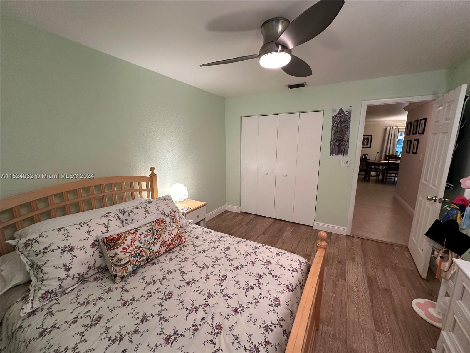 14944 Southwest 144th Court Miami, FL 33186 - Photo 19 of 34 a bedroom with a bed and wooden floor