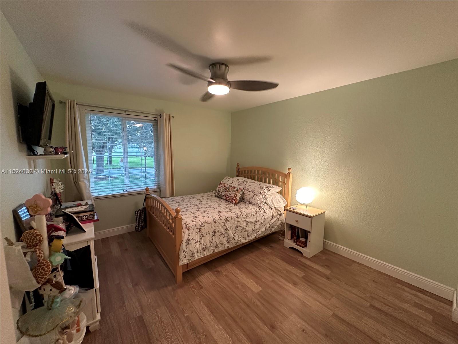 14944 Southwest 144th Court Miami, FL 33186 - Photo 20 of 34 a bedroom with a bed and a flat tv screen on the dresser