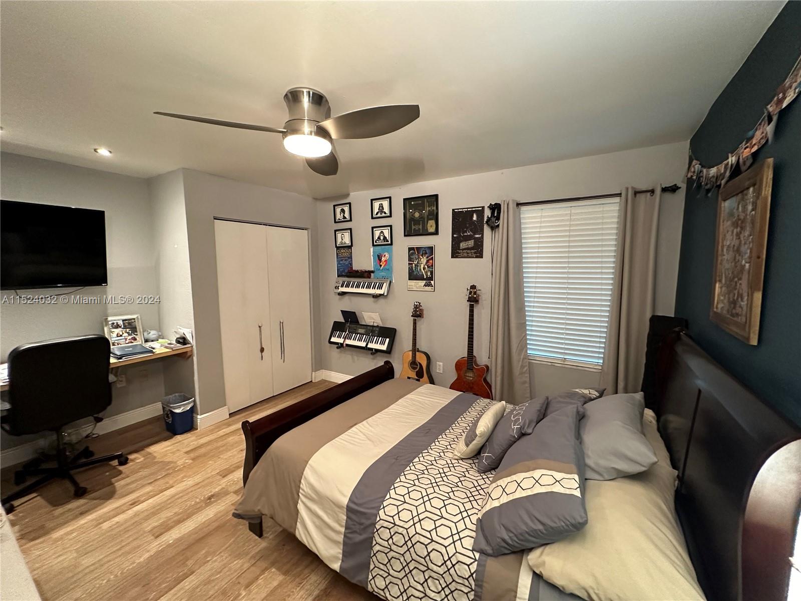 14944 Southwest 144th Court Miami, FL 33186 - Photo 22 of 34 a bedroom with a bed window and a flat screen tv