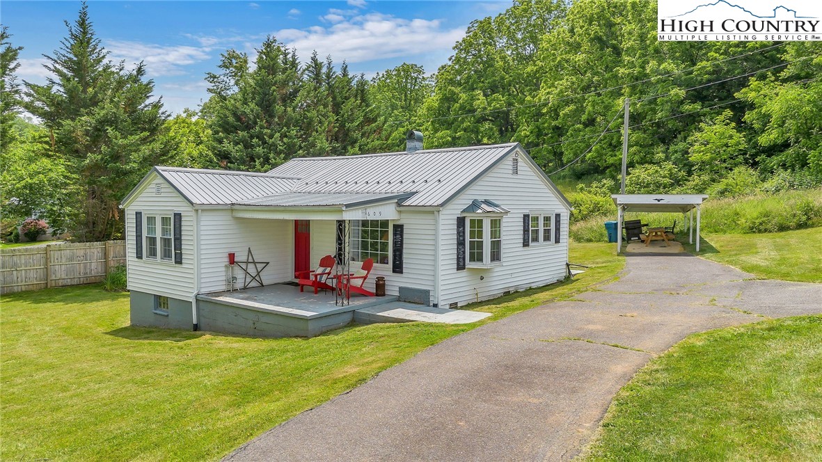 a front view of a house with swing and chairs