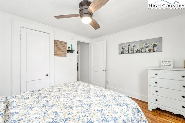 a bedroom with a bed and a chandelier fan